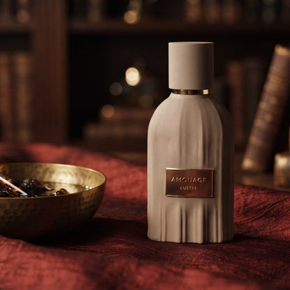 Amouage Lustre Essence de Parfum on raw silk of oxblood color with a brass bowl with ambergris tincture