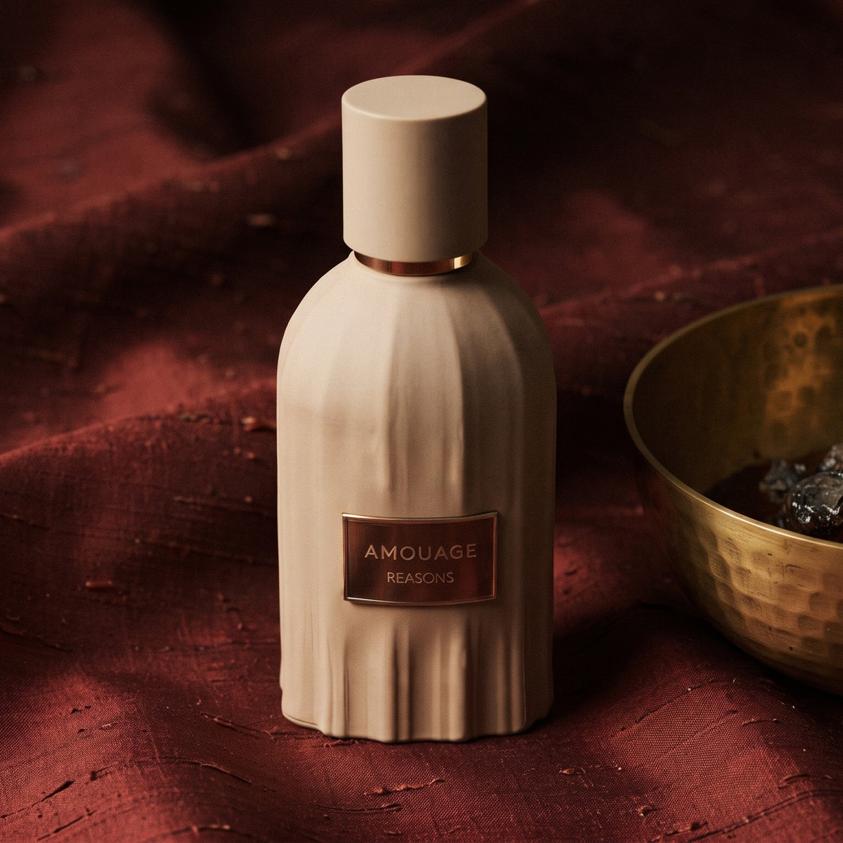 Amouage Reasons Essence de Parfum on raw silk of oxblood color with a brass bowl with ambergris tincture