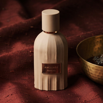 Amouage Reasons Essence de Parfum on raw silk of oxblood color with a brass bowl with ambergris tincture