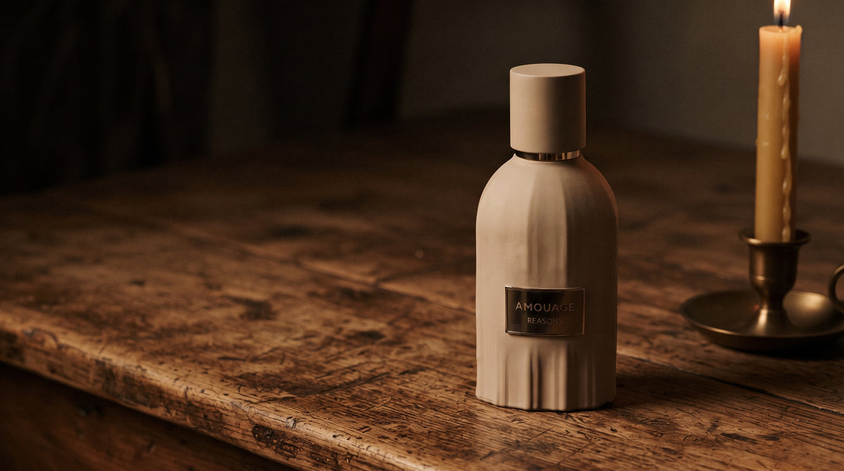Amouage Reasons Essence de Parfum on aged teak with a candle burning gently to frame-right