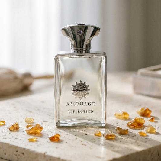 Amouage Reflection EDP on cream stone with a scatter of honey-colored ambergris flakes