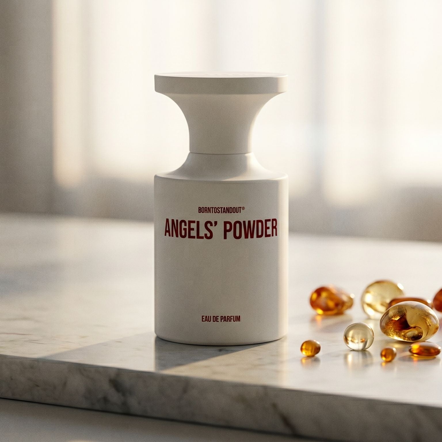 Borntostandout Angels EDP on cream stone with a scatter of honey-colored ambergris flakes
