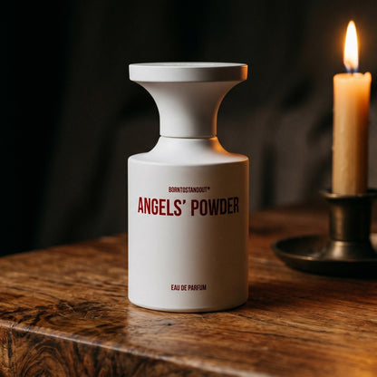 Borntostandout Angels EDP on aged teak with a candle burning gently to frame-right