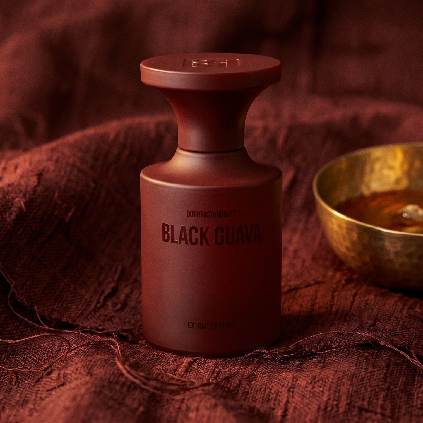 Borntostandout Black Guava Extrait Extreme on raw silk of oxblood color with a brass bowl of ambergris tincture