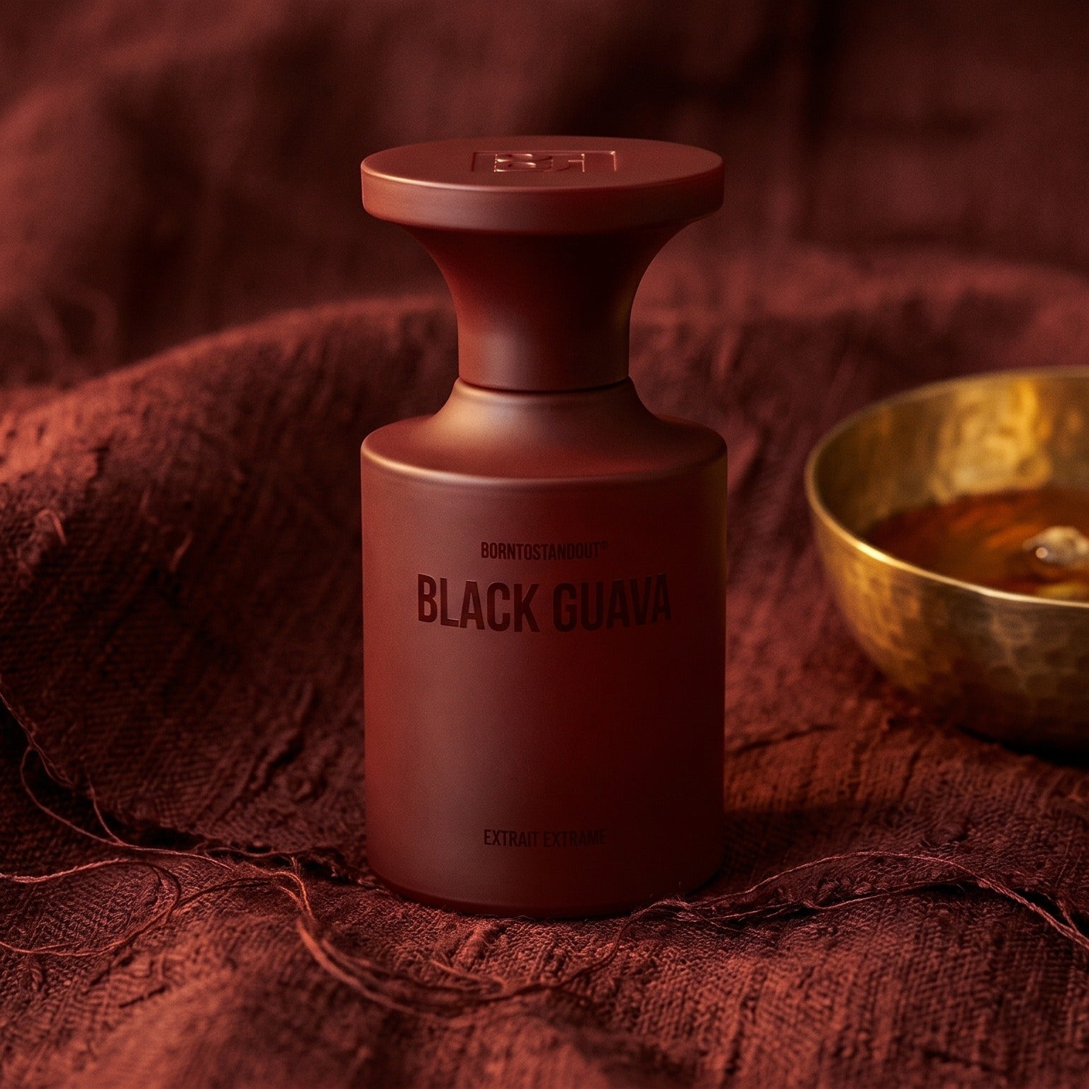 Borntostandout Black Guava Extrait Extreme on raw silk of oxblood color with a brass bowl of ambergris tincture