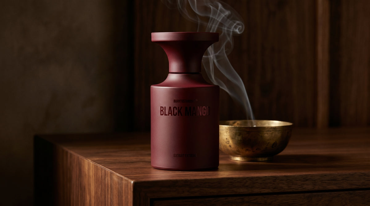 Borntostandout Black Mango Extrait Extreme on dark walnut console with a small brass incense bowl with smoke curling upward