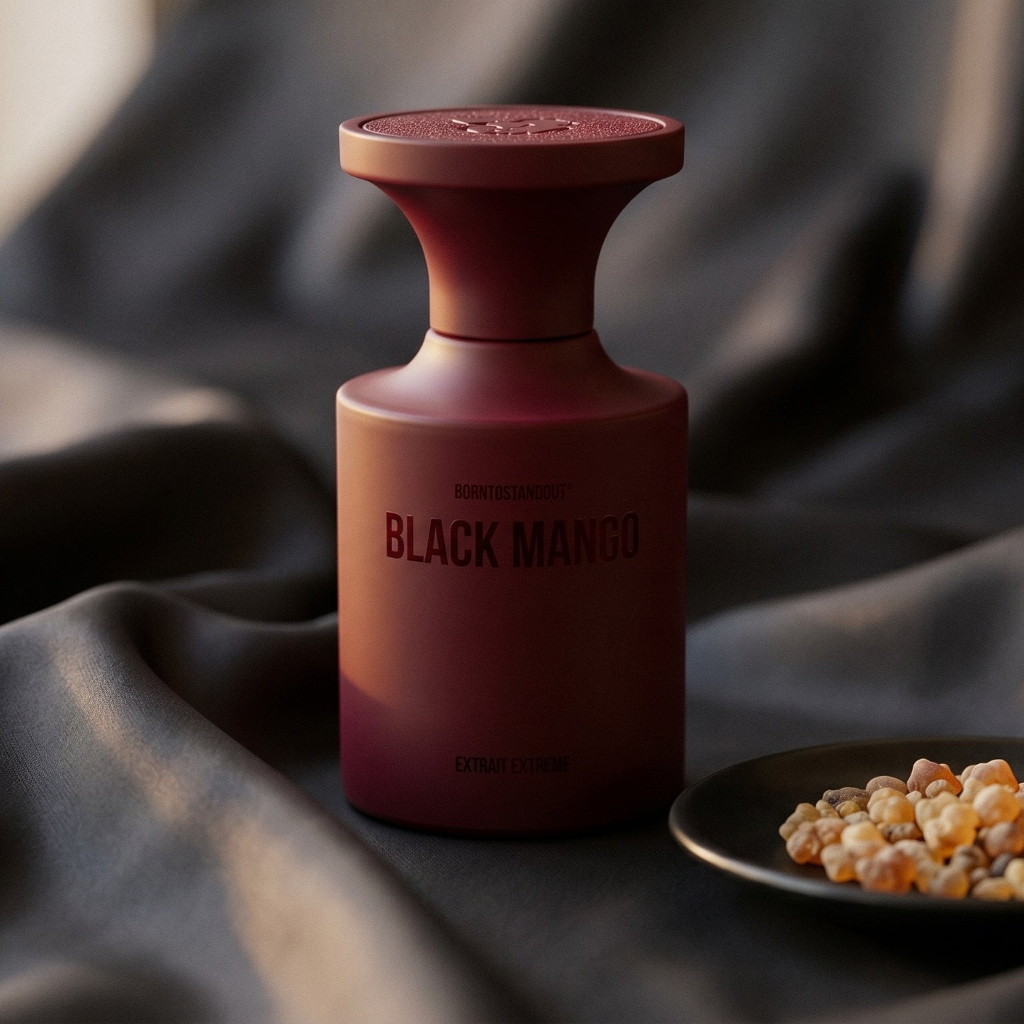 Borntostandout Black Mango Extrait Extreme on charcoal silk with frankincense resin granules in a small saucer