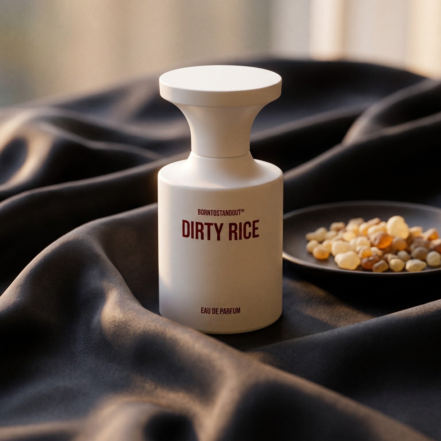 Borntostandout Dirty Rice EDP on burnt-orange silk with smoldering agarwood on a stone dish