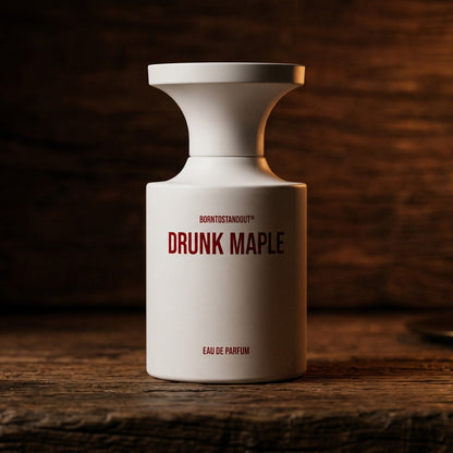 Borntostandout Drunk Maple EDP on rosewood surface with a squat brass candle flickering nearby