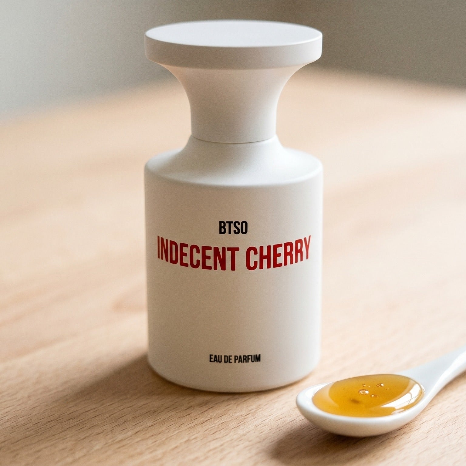 Borntostandout Indecent Cherry EDP on birch surface with a glass jar of demerara sugar