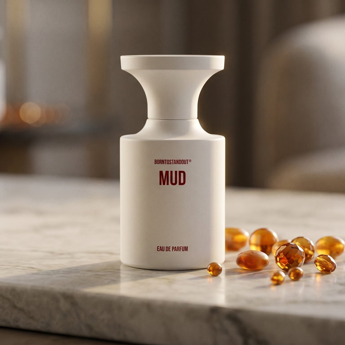 Borntostandout Mud EDP on pale grey marble with amber resin beads scattered to one side