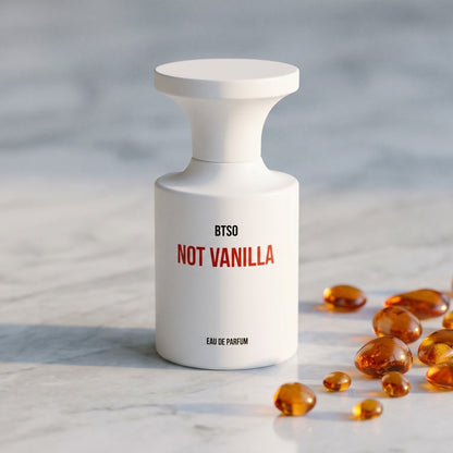 Borntostandout Not Vanilla EDP on warm ivory travertine with labdanum chunks clustered by the base
