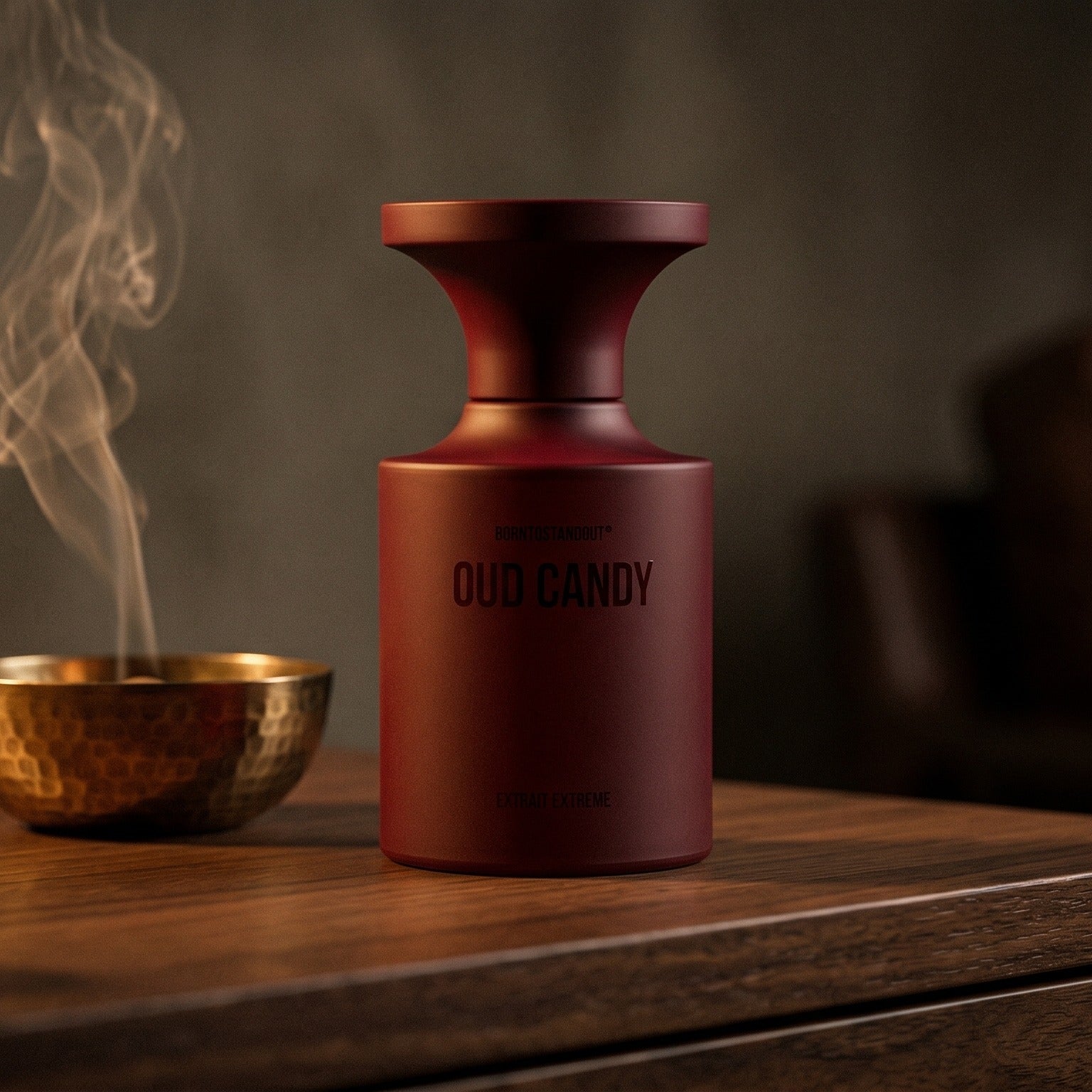 Borntostandout Oud Candy Extrait Extreme on aged walnut board with dried agarwood shavings scattered loosely