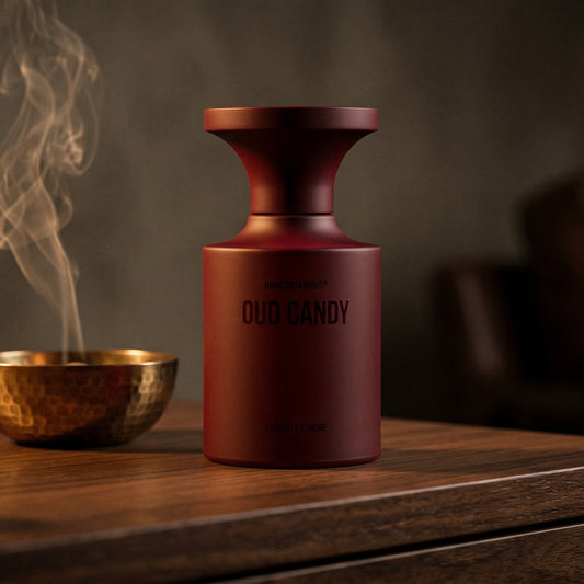 Borntostandout Oud Candy Extrait Extreme on aged walnut board with dried agarwood shavings scattered loosely