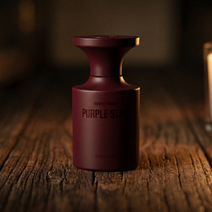 Borntostandout Purples Stain Extrait Extreme on aged maple with a slender candlestick and drifting smoke