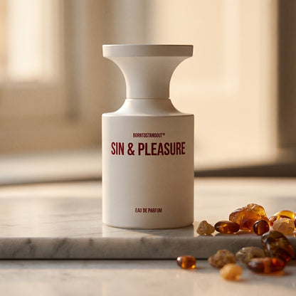 Borntostandout Sin & Pleasure EDP on warm taupe marble with copal beads spilling from a small dish