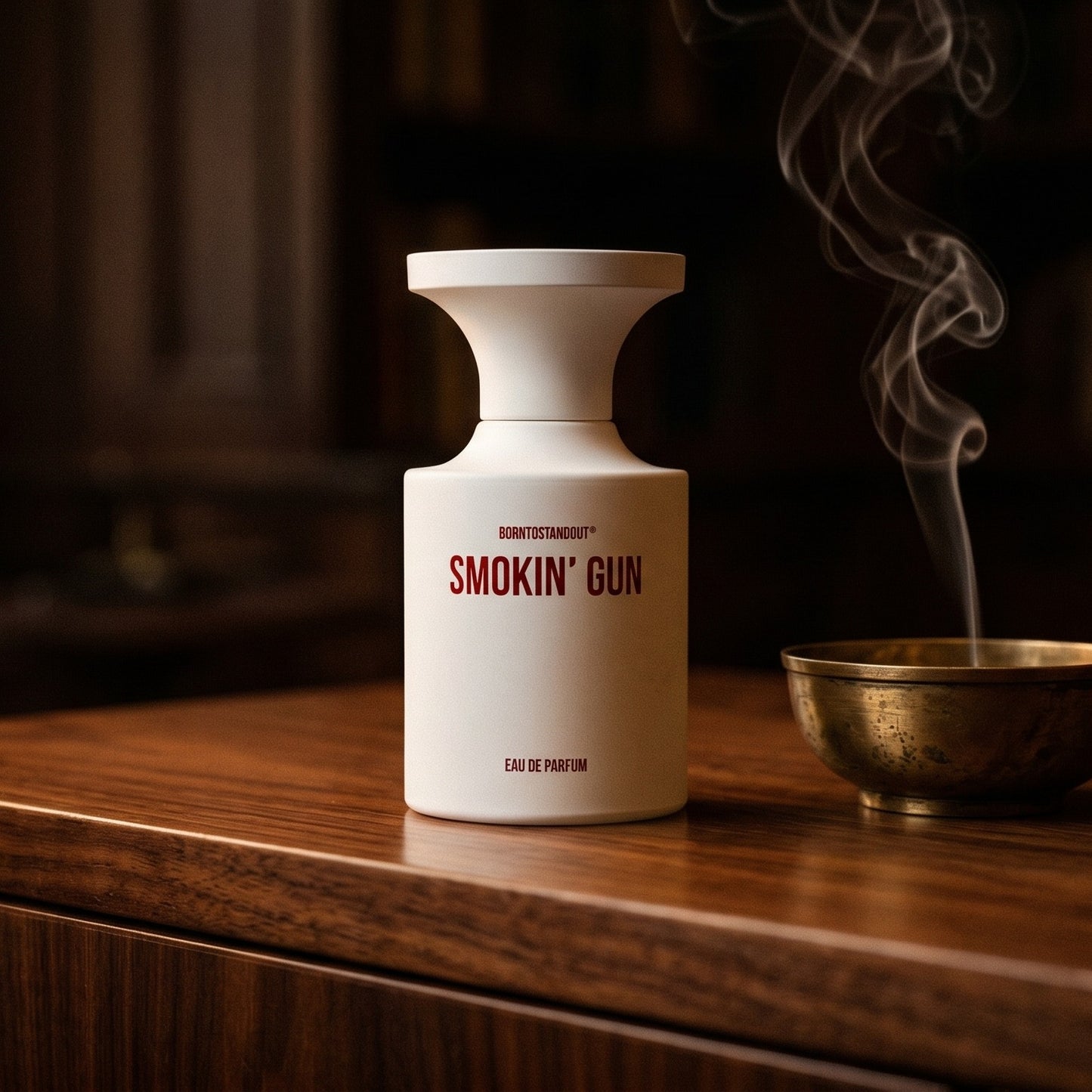 Borntostandout Smokin Gun EDP on ebony surface with a hammered copper censer releasing frankincense haze