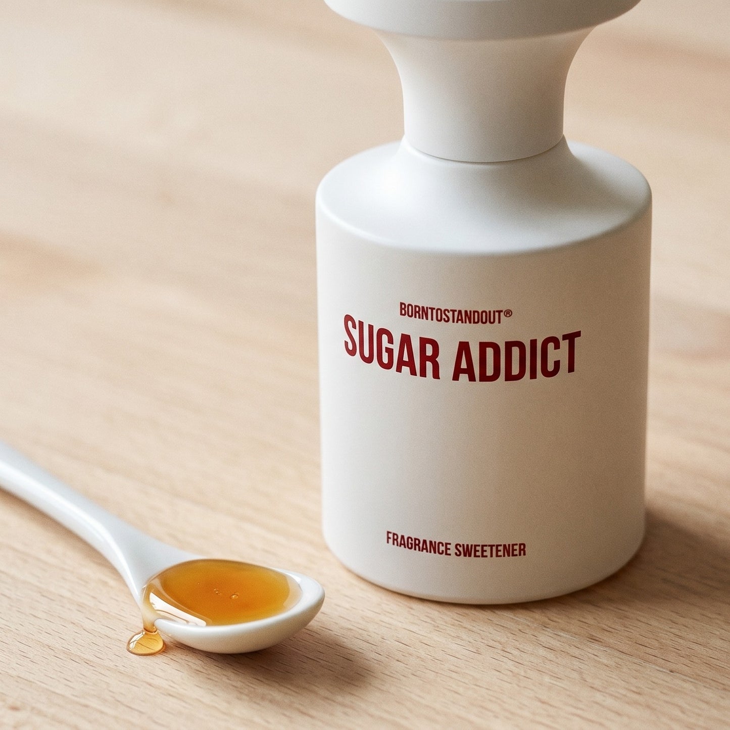Borntostandout Sugar Addict EDP on bleached oak with a shallow ramekin of salted caramel