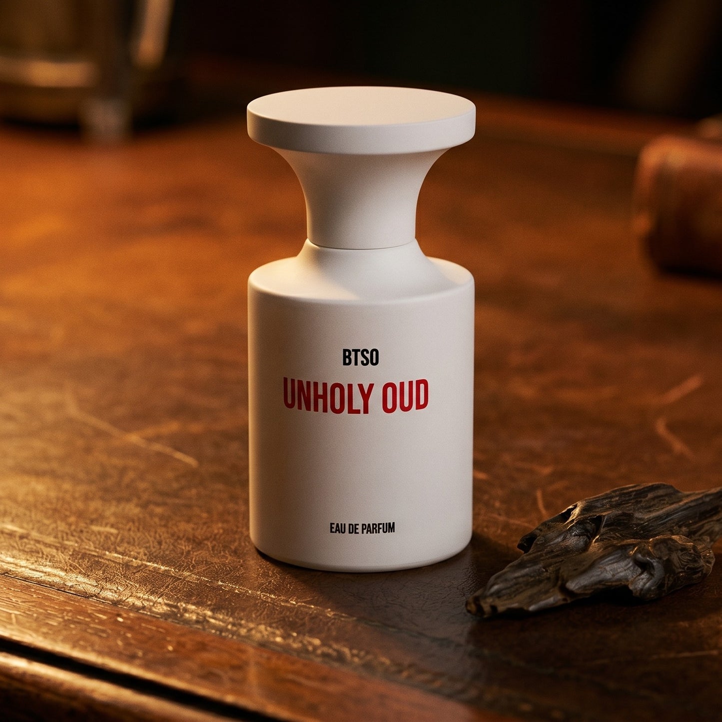 Borntostandout Unholy Oud EDP on aged library leather with a small stack of resinous wood splinters