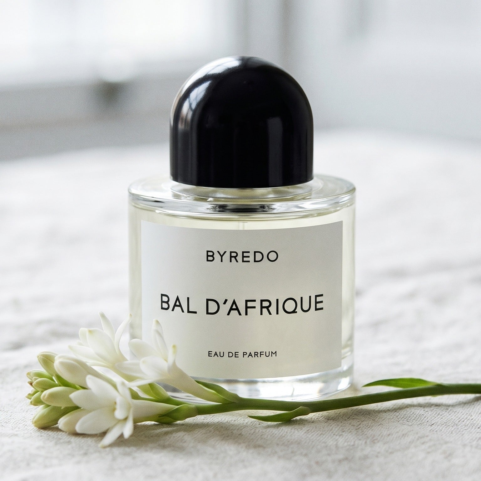 Byredo Bal'd Afrique on pale muslin with a spray of osmanthus and jasmine petals