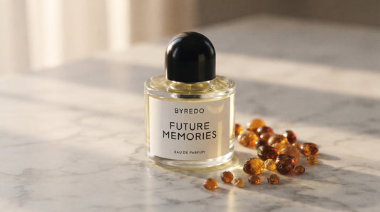 Byredo Future Memories EDP on pale grey marble with amber resin beads scattered to one side