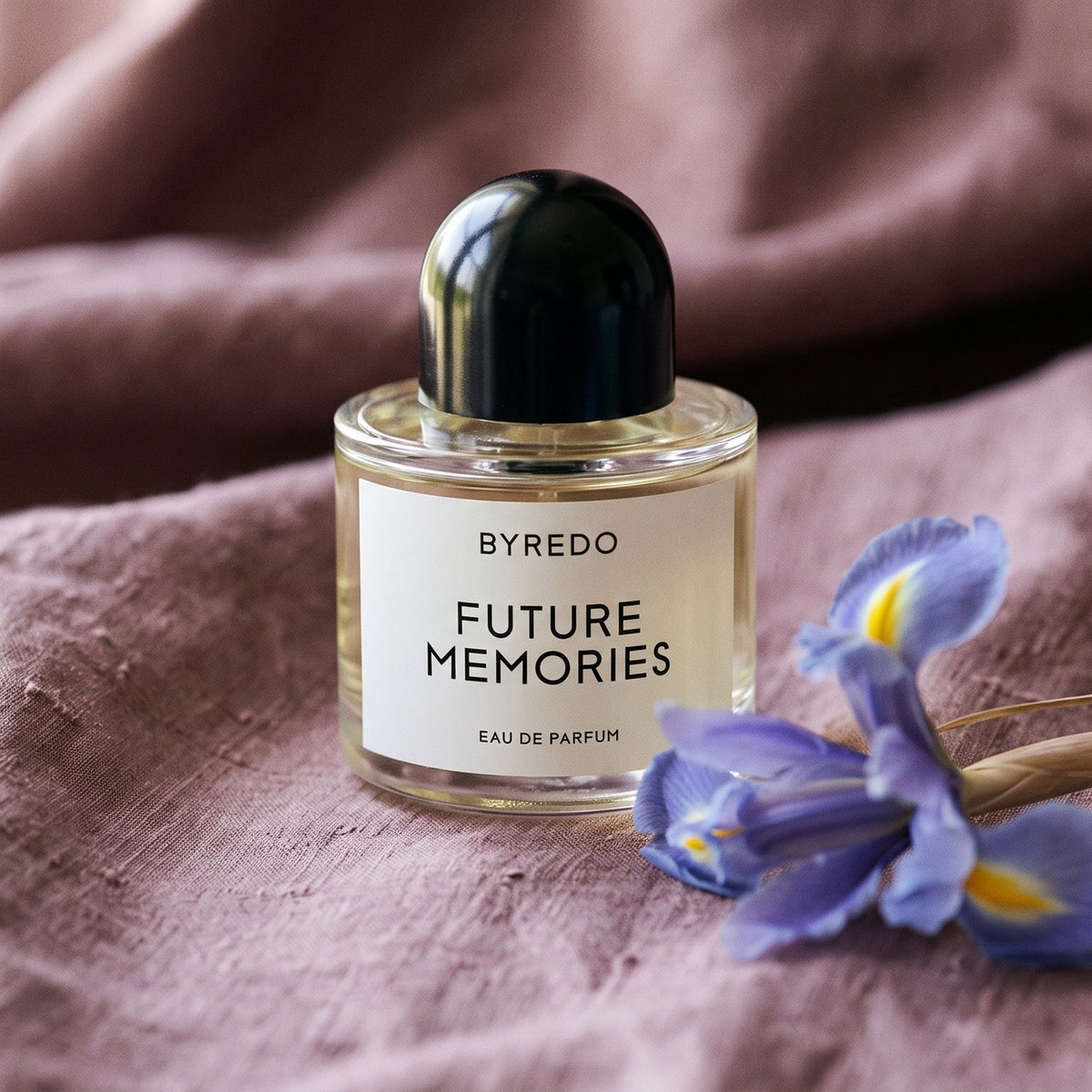 Byredo Future Memories EDP on raw silk in dusty mauve with two iris flowers laid softly