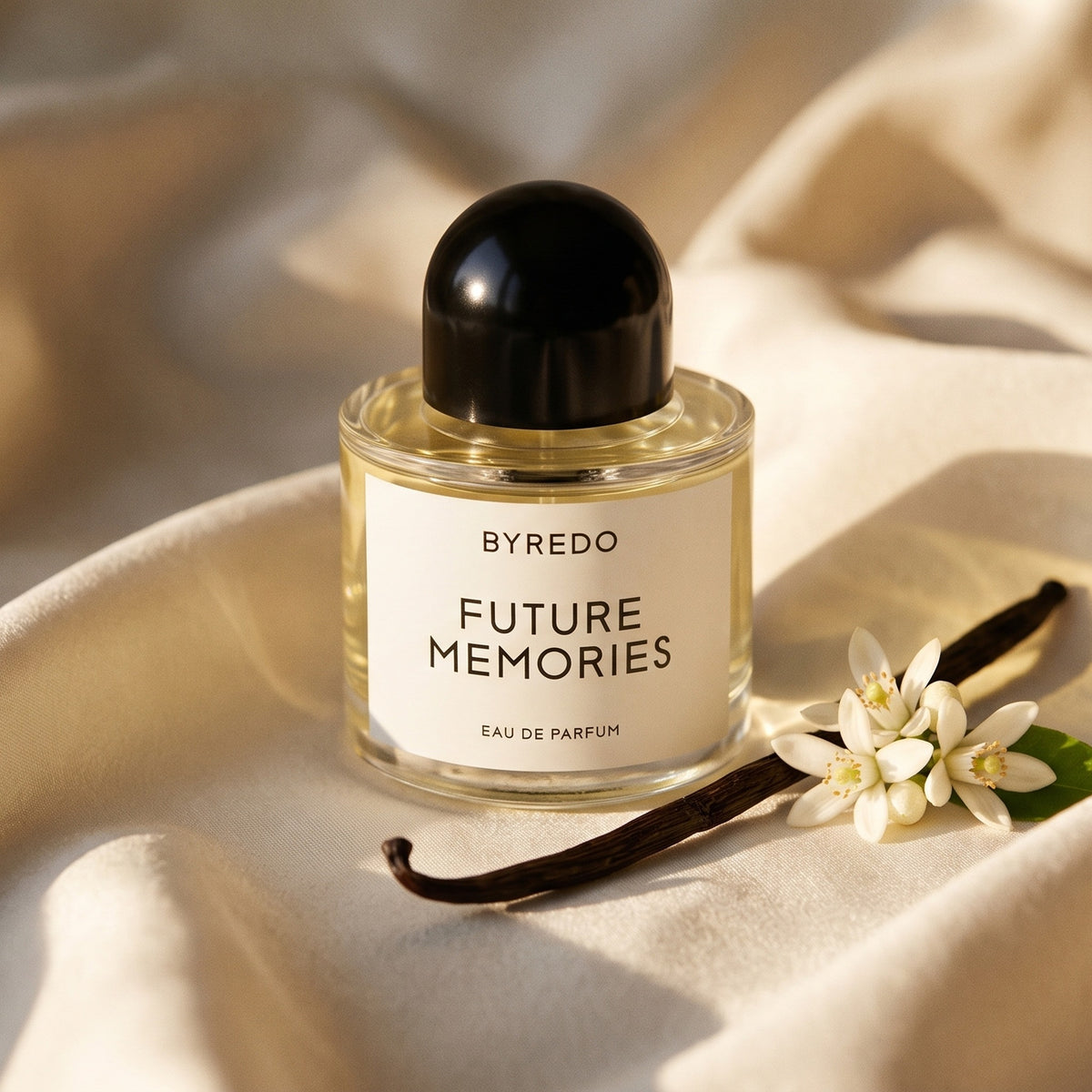 Byredo Future Memories EDP on cream silk with a vanilla pod beside a few orange blossoms