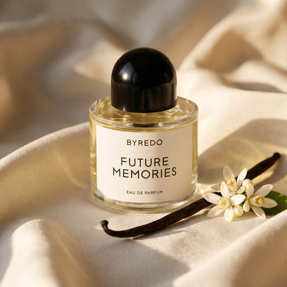 Byredo Future Memories EDP on cream silk with a vanilla pod beside a few orange blossoms