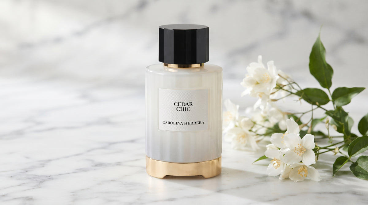 Carolina Herrera Cedar Chic EDP on white carrara marble with jasmine sprigs placed to frame-right