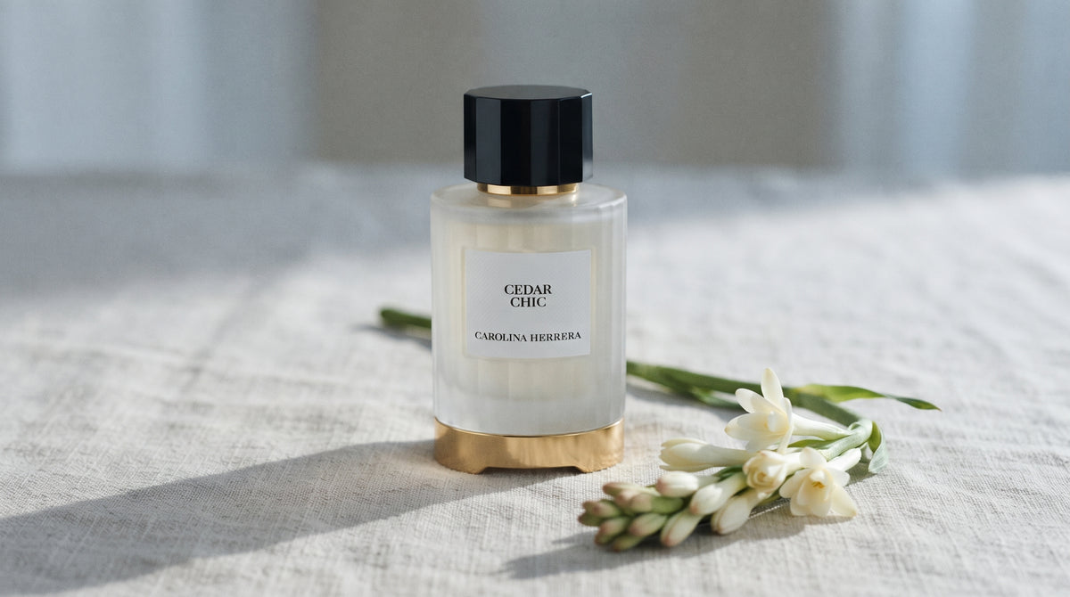 Carolina Herrera Cedar Chic EDP on bleached linen with a single tuberose stem laid flat