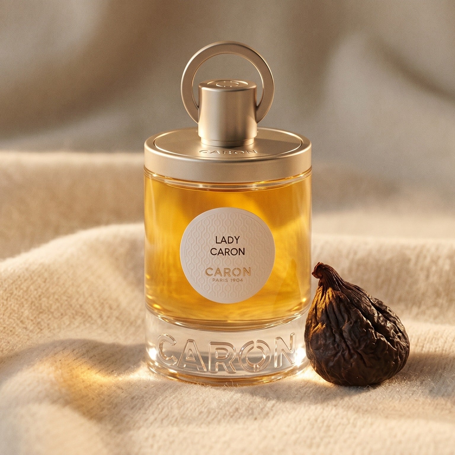 Caron Lady Caron EDP on ivory cashmere with a small cluster of spiced walnuts
