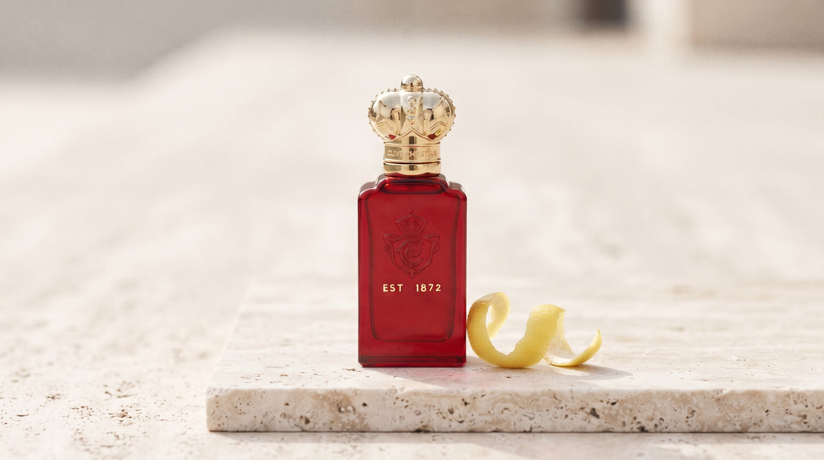 Clive Christian Crab Apple Blossom EDP on pale travertine with a lemon peel curled beside the bottle
