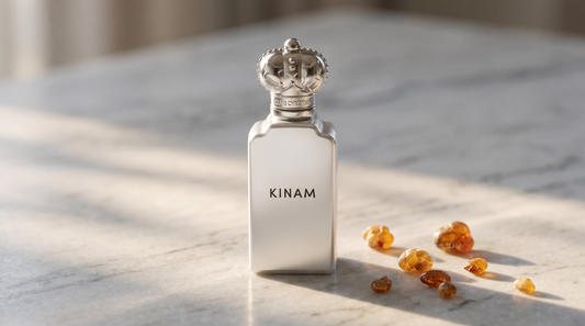 Clive Christian Kinam Parfum - Dubai Exclusive on pale grey marble with amber resin beads scattered to one side