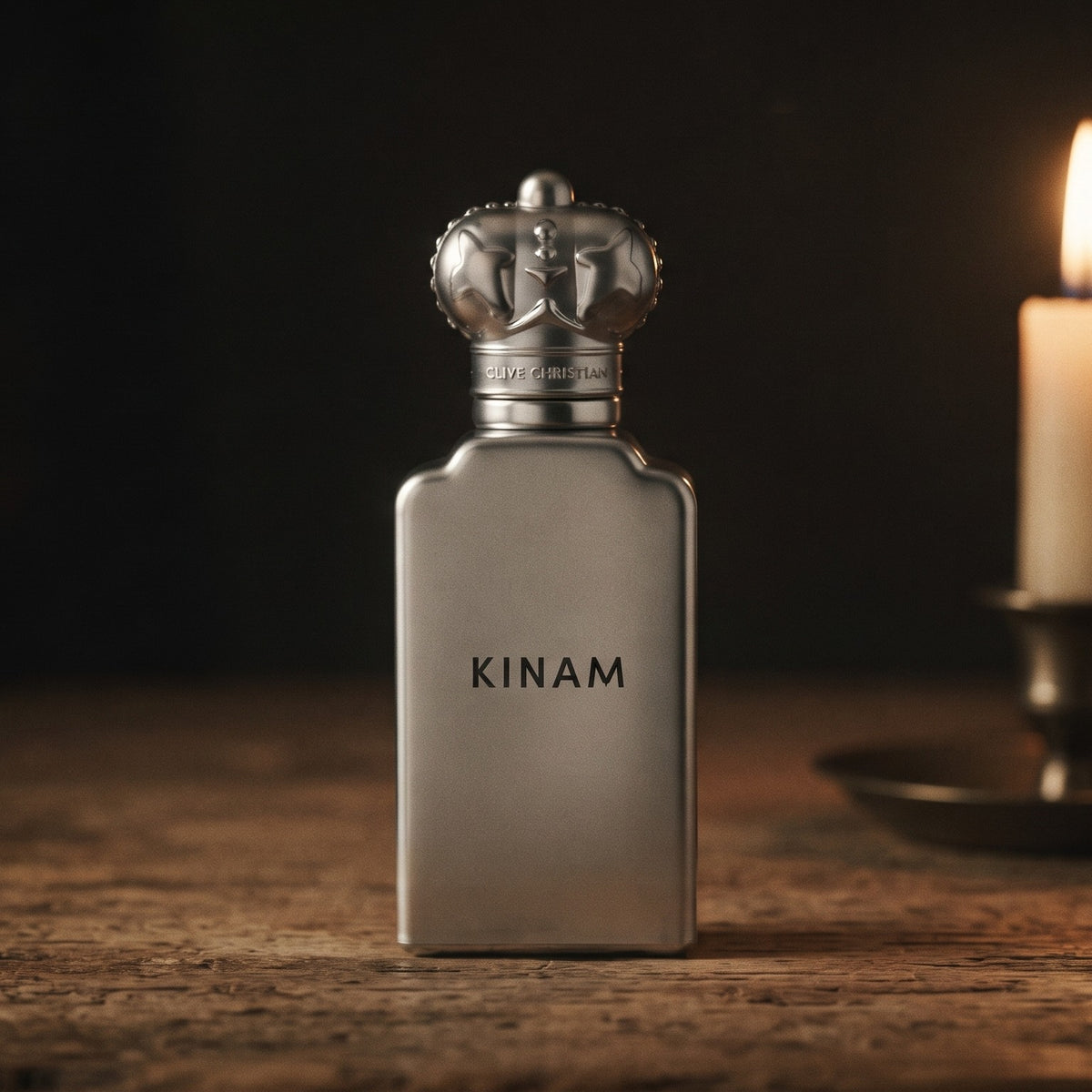 Clive Christian Kinam Parfum - Dubai Exclusive on aged teak with a candle burning gently to frame-right