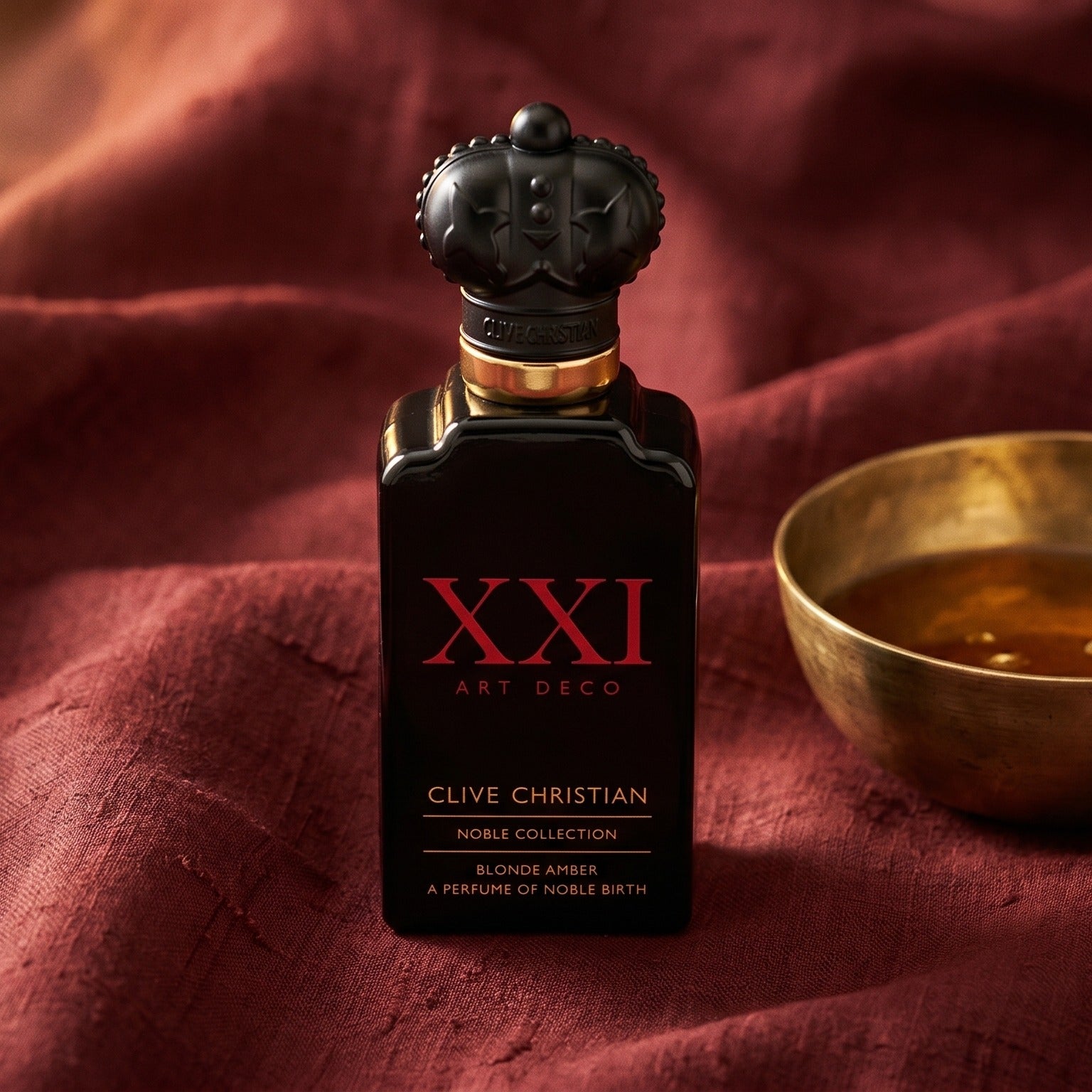 Clive Christian XXI Blonde Amber on russet silk with a matte brass bowl holding tonka and amber pieces