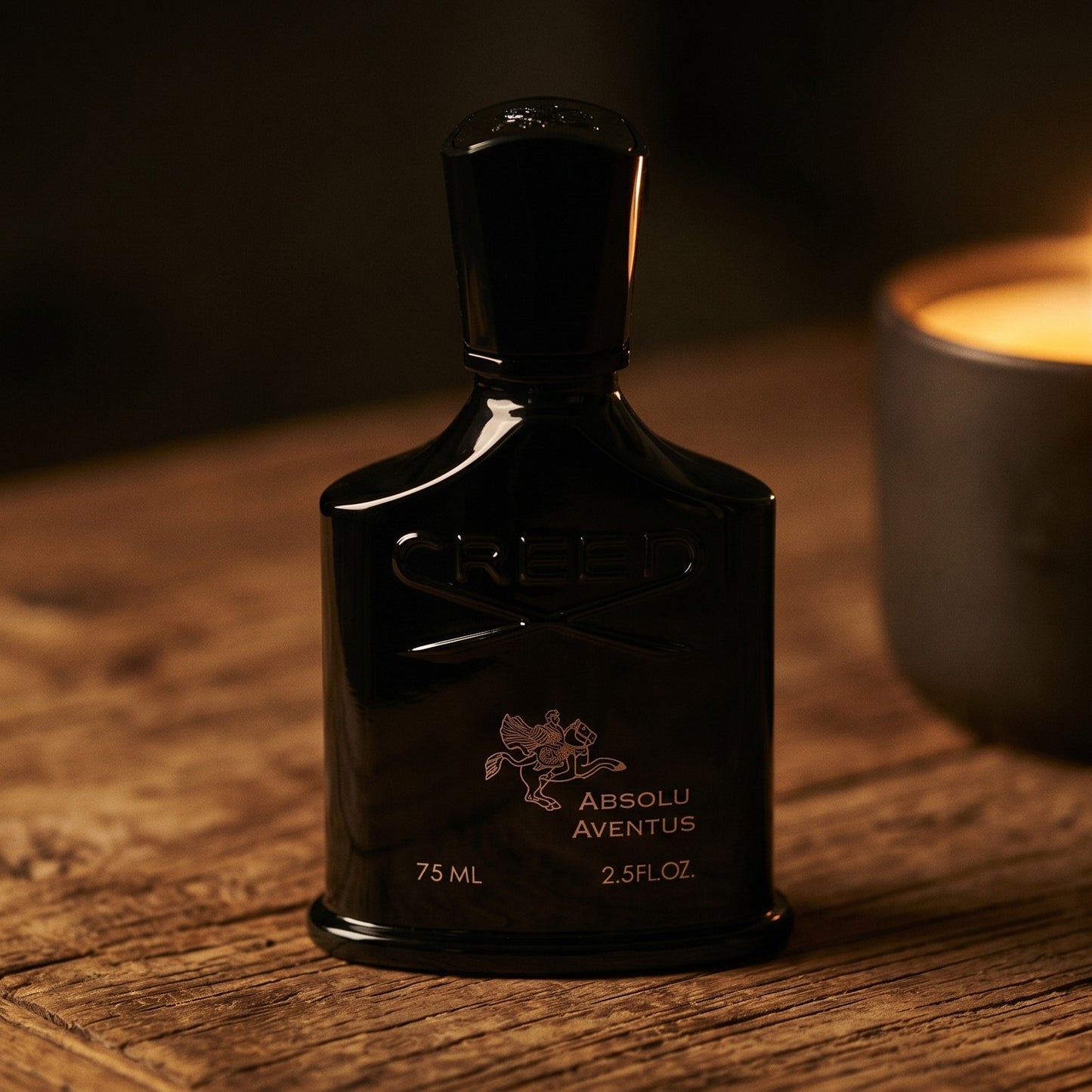 Creed Absolu Aventus on walnut side table with a pair of lit votives beside the bottle
