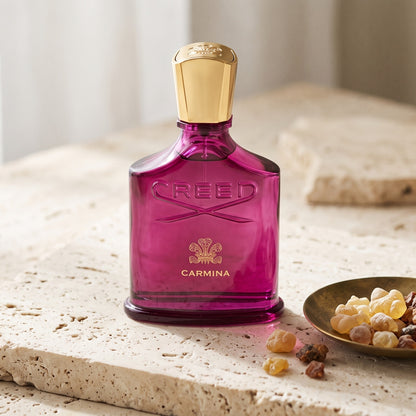 Creed Carmina on cream stone with frankincense and myrrh resin in a small brass dish