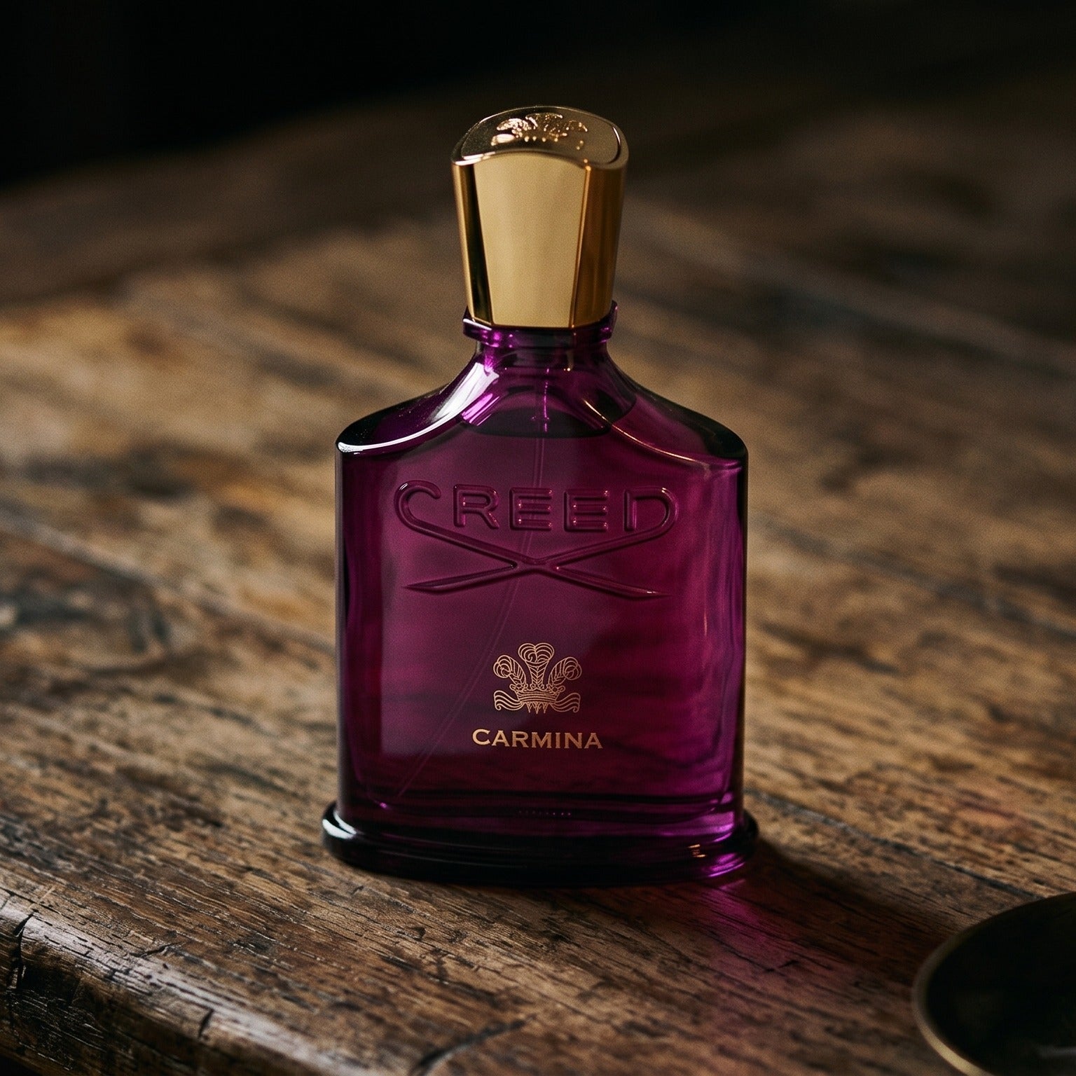 Creed Carmina on rosewood surface with a squat brass candle flickering nearby