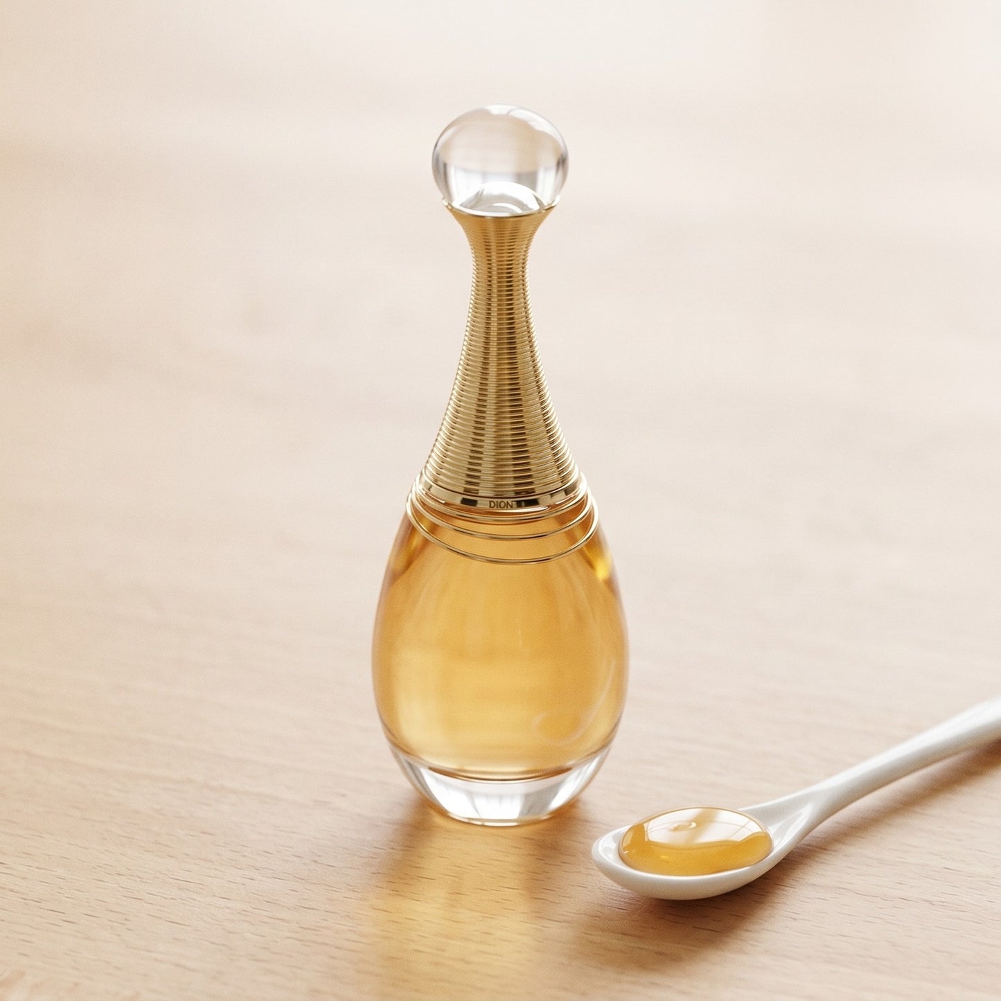 Dior J’adore on pale beech wood with a small porcelain spoon of honey