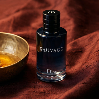 Dior Sauvage on raw silk of oxblood color with a brass bowl of ambergris tincture