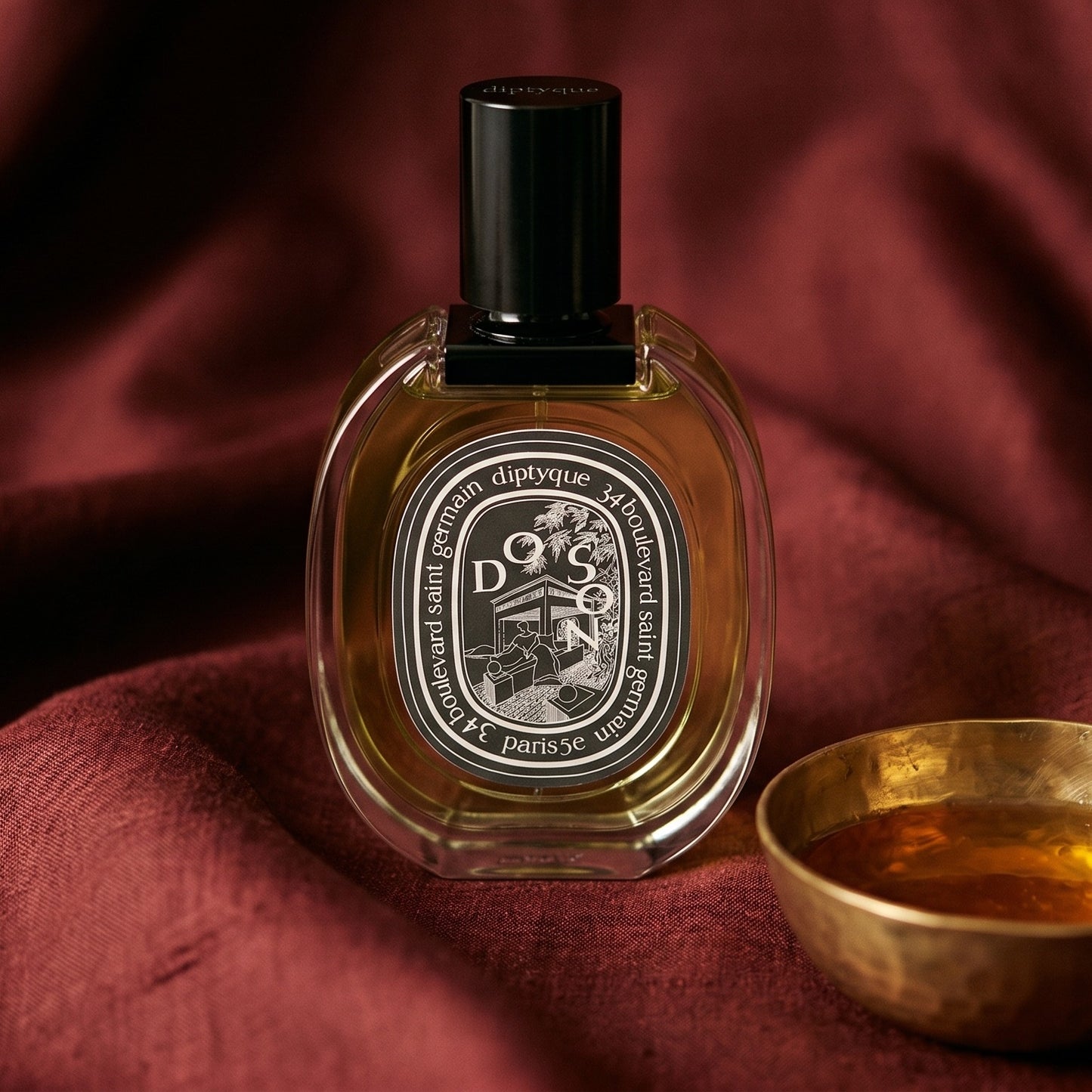 Diptyque Doson EDP on cinnamon-tone silk with a shallow saucer of warm benzoin resin