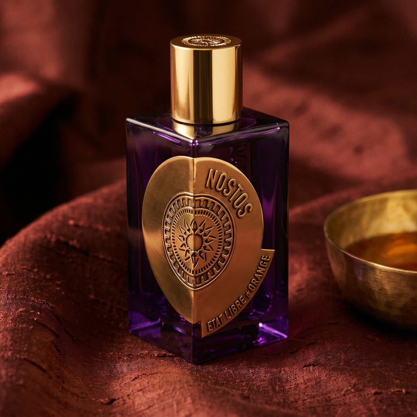 Etat Libre Nostos on raw silk of oxblood color with a brass bowl of ambergris tincture