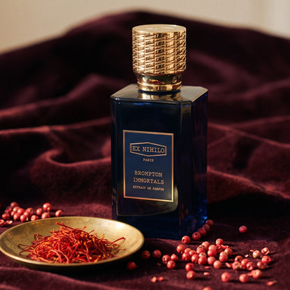 Ex Nihilo Brompton Immortals Extrait de Parfum on dark burgundy velvet with saffron threads and pink peppercorns