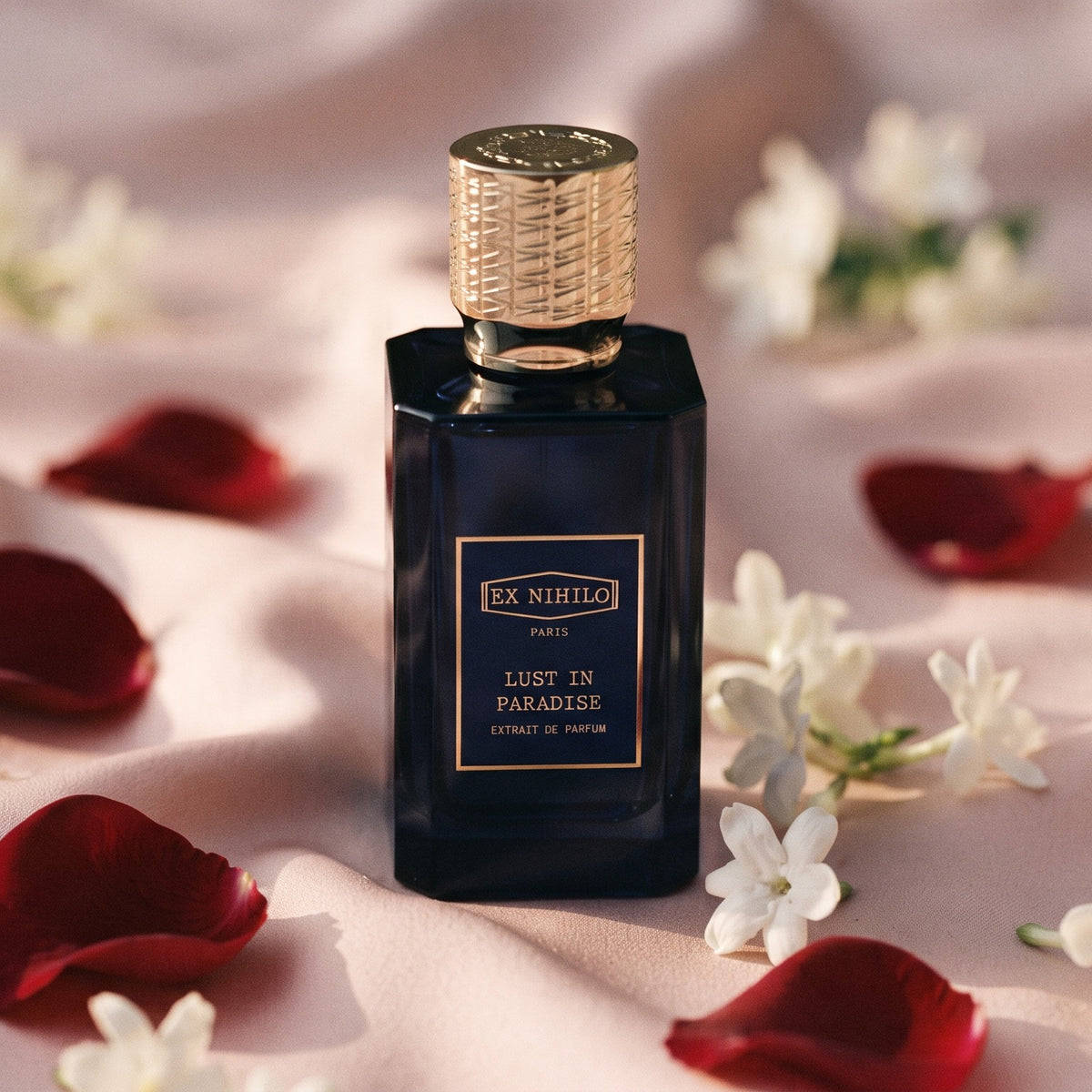 Ex Nihilo Lust in Paradise Extrait de Parfum on pale pink silk with rose petals and jasmine