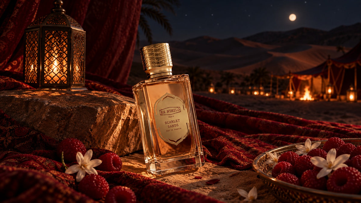 Ex Nihilo Scarlet Sands EDP bottle on red silk beside a brass lantern, with a moonlit desert camp behind