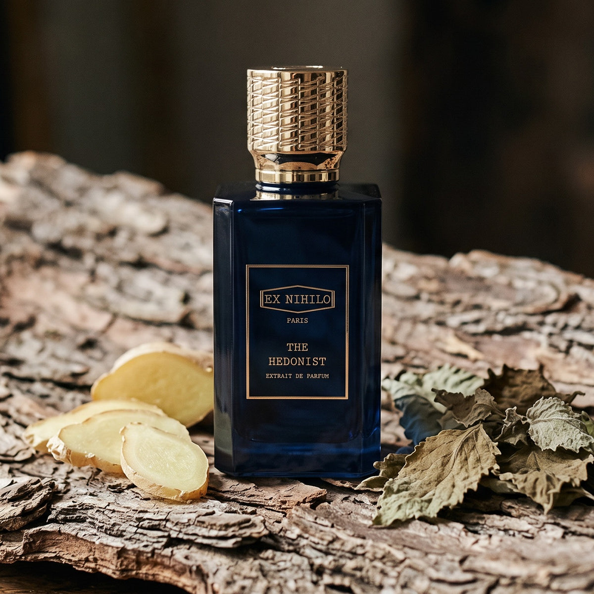 Ex Nihilo The Hedonist Extrait de Parfum on weathered cedarwood bark with ginger slices and patchouli leaves