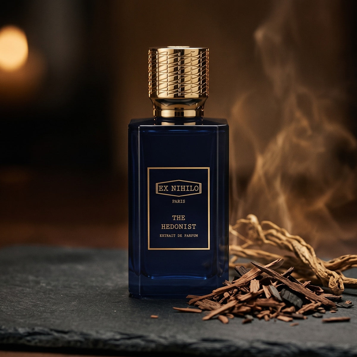 Ex Nihilo The Hedonist Extrait de Parfum on dark charcoal slate with wood shavings and vetiver roots