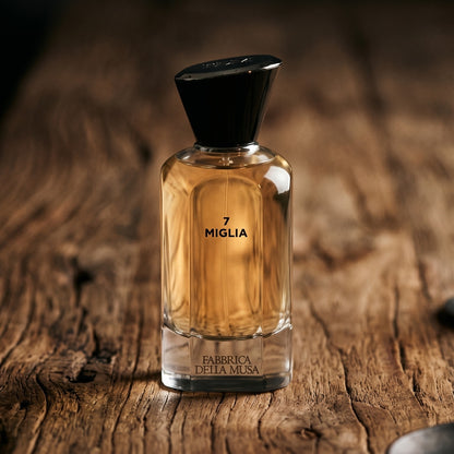 Fabbrica Della Musa 7 Migila EDP on aged maple with a slender candlestick and drifting smoke