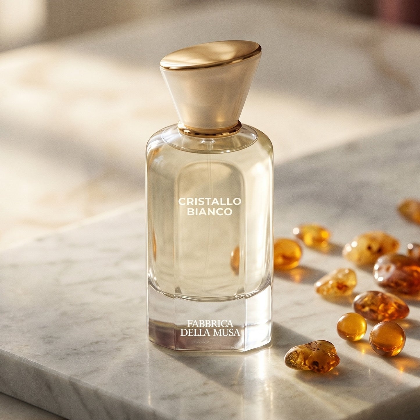 Fabbrica Della Musa Cristallo Bianco EDP on pale grey marble with amber resin beads scattered to one side