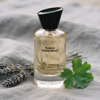 Fabbrica Della Musa Magia Maertrale EDP on soft grey linen with dried lavender sprigs and a geranium leaf
